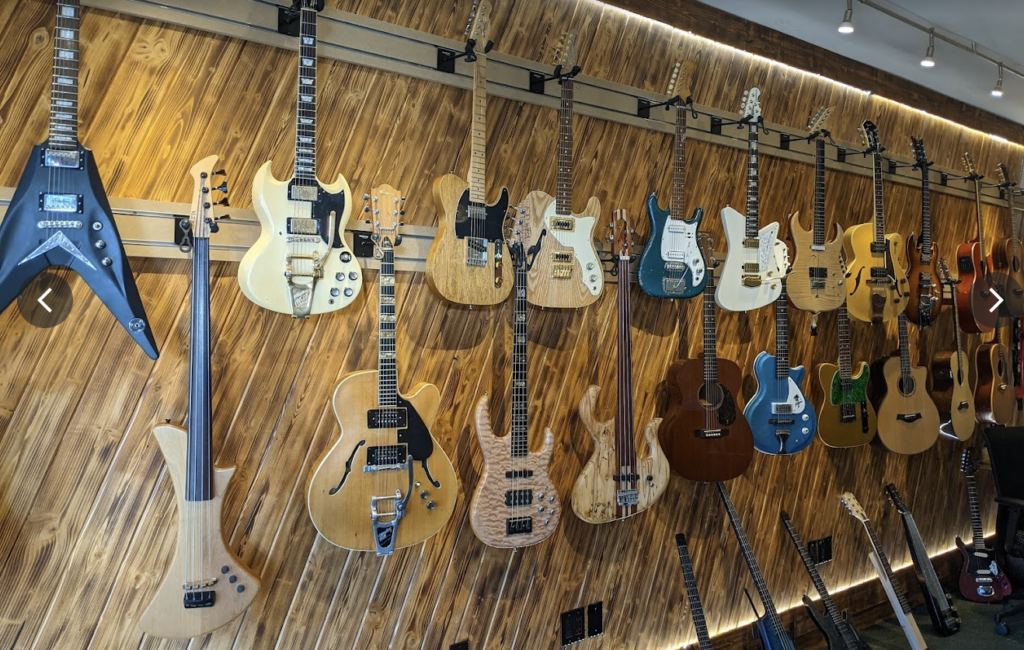 Rows of guitars displayed on the wall at the guitar store, Diamond Music. 
